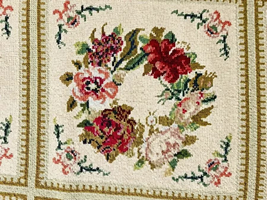 Floral needlepoint rug after professional correction of dye bleed in the pale background
