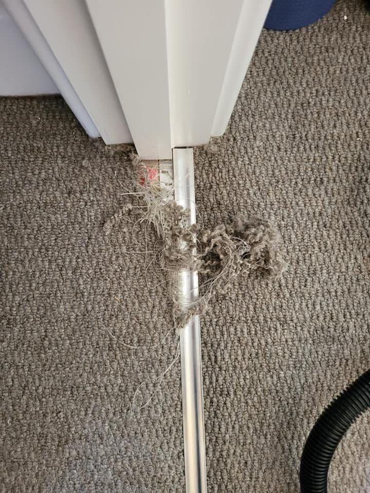 Pulled and missing carpet pile at a doorway before patch repair
