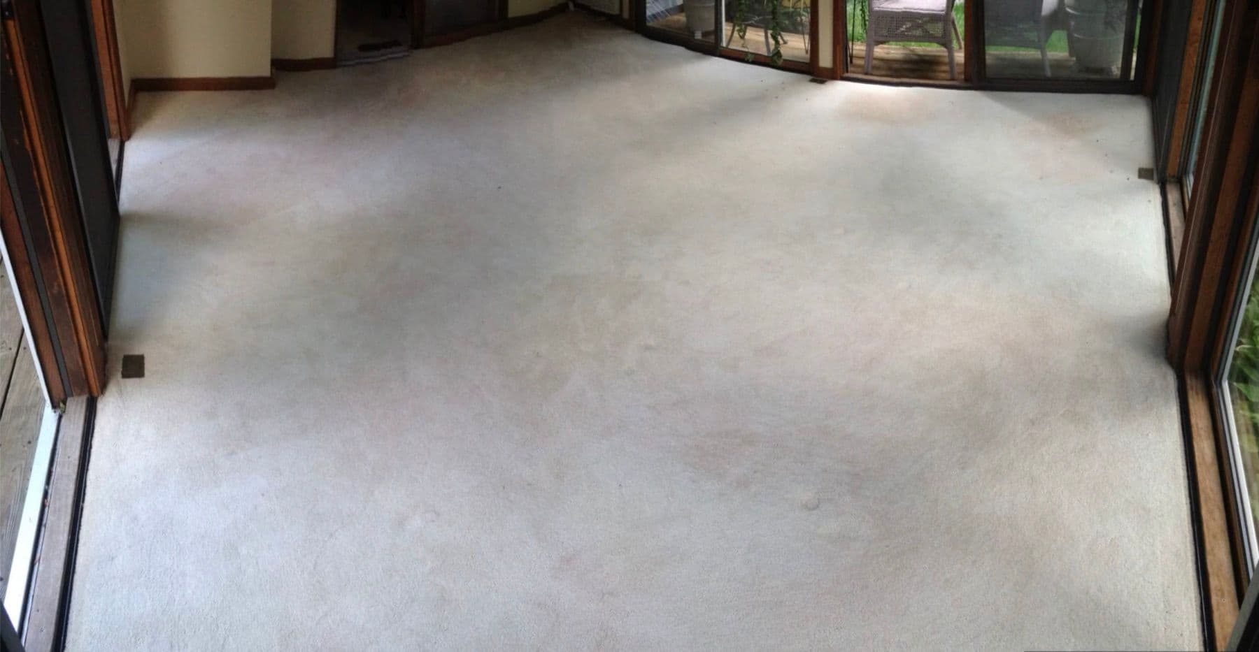 Conservatory carpet with uneven colour loss before professional restoration