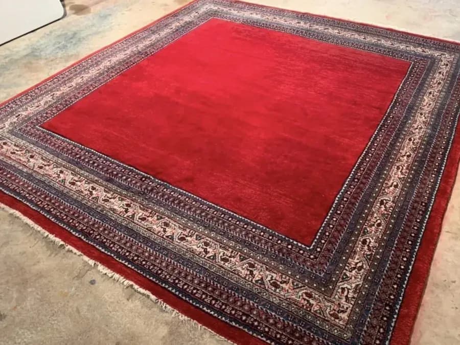 Large patterned rug after professional restoration of the faded red field