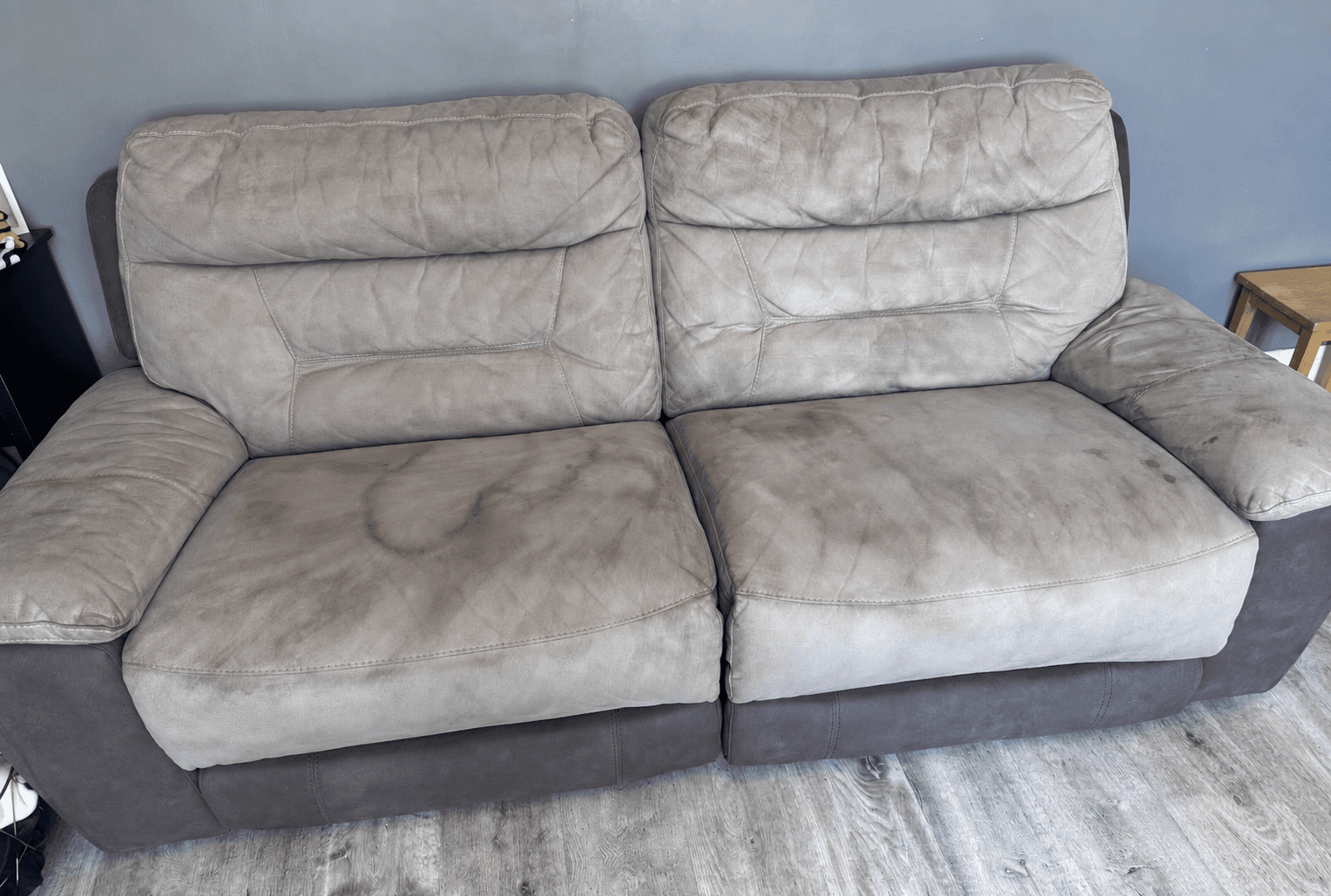 Light-coloured sofa with visible pet-related staining before upholstery cleaning and odour treatment